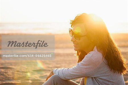 Smiling woman in sunglasses on beach