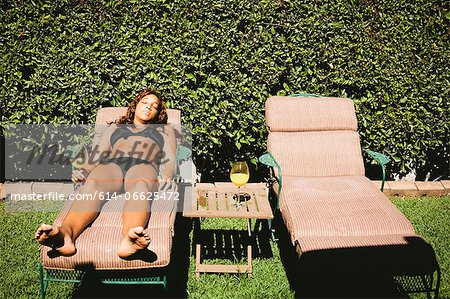 Woman in bikini sunbathing in lawn chair