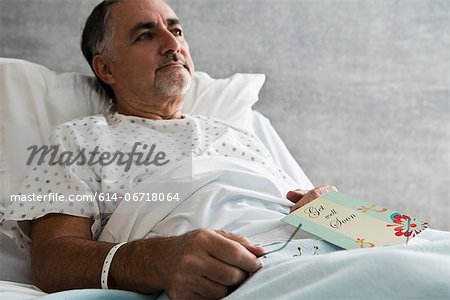 Male hospital patient with get well soon card