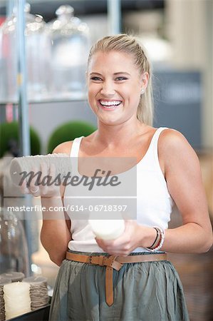 Laughing woman holding candles in store