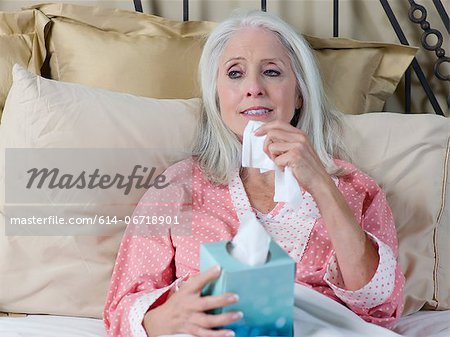 Sick older woman laying in bed