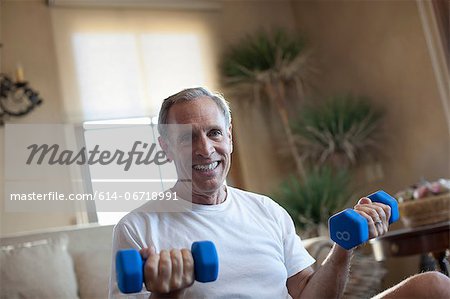 Older man lifting weights at home