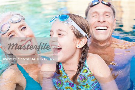 Girl and grandparents swimming in pool