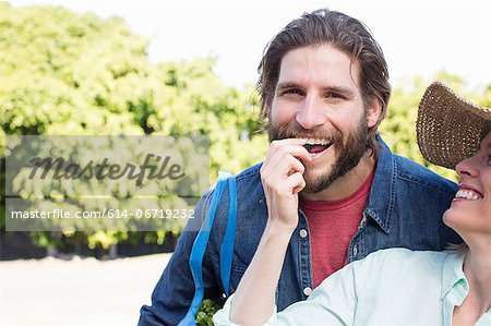 Woman feeding boyfriend fruit outdoors