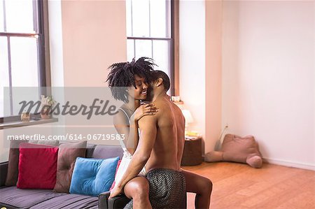 Couple kissing on sofa in living room