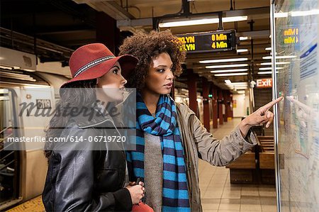 Women reading map in subway station