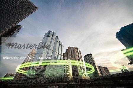 Green light trails surrounding skyscrapers