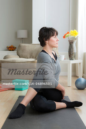 Mid adult woman doing yoga at home