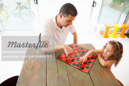 Father and daughter playing draughts