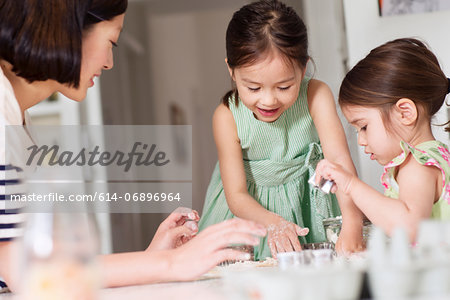 Mother and young daughters making pastry