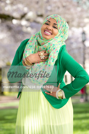 Portrait of young female in park wearing green