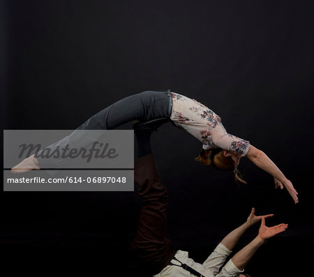 Studio shot of acrobats performing balancing trick