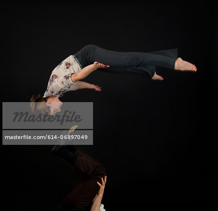 Studio shot of acrobats performing mid air