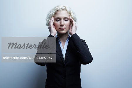 Studio portrait of businesswoman with hands on face