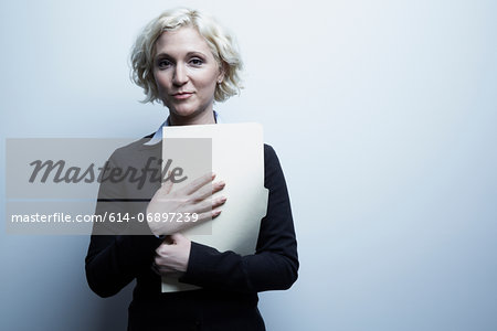 Studio portrait of businesswoman holding file