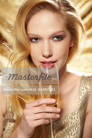Close up portrait of young woman holding champagne flute