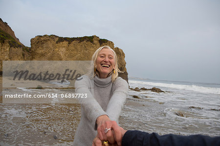 Mature couple holding hands on beach