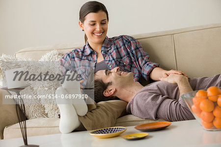 Couple on sofa, man with head on woman's lap