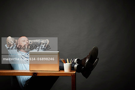 Man sitting back with legs on table