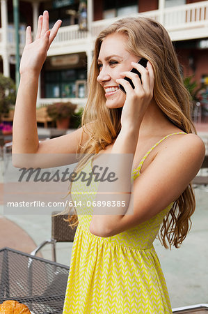 Woman on mobile phone waving