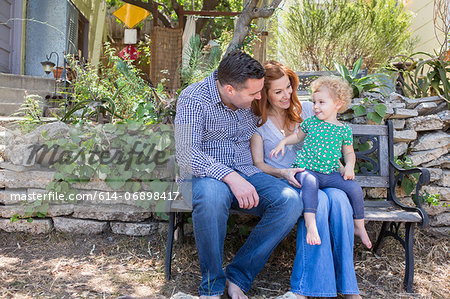 Husband & wife smiling at child