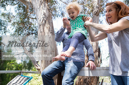 Parents swinging child by the arms