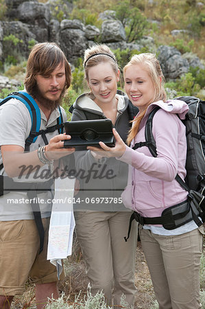 Young hikers looking at hand held computer