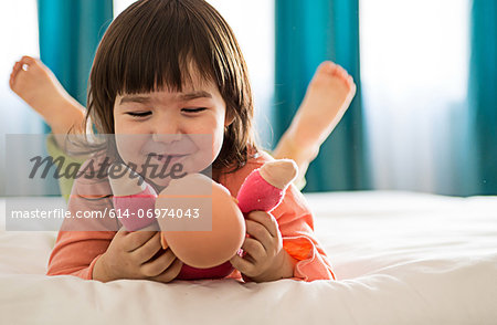 Girl playing with dolly in bedroom