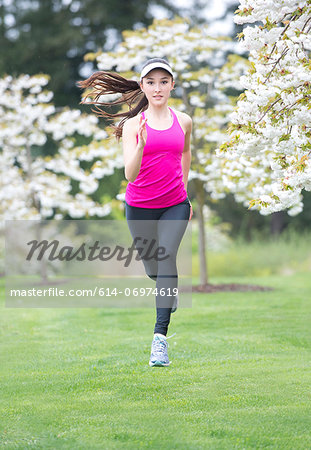 Teenage girl wearing pink sportswear running in park