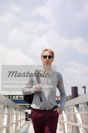 Young man walking over footbridge, Brooklyn, New York City, USA