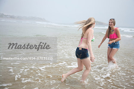 Young women playing in tide on beach