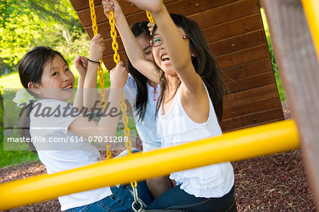 Three girls playing on swing