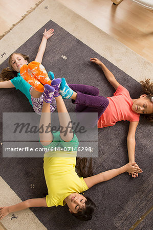 Three girls lying on floor with legs raised