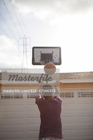 Boy throwing basketball towards hoop