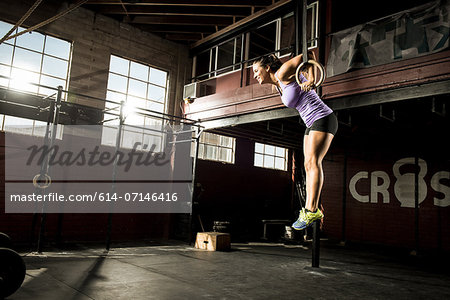 Young woman exercising on gymnastic ring