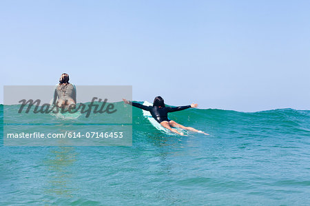 Female friends surfing, Hermosa Beach, California, USA