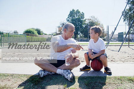 Man giving grandson basketball pep talk