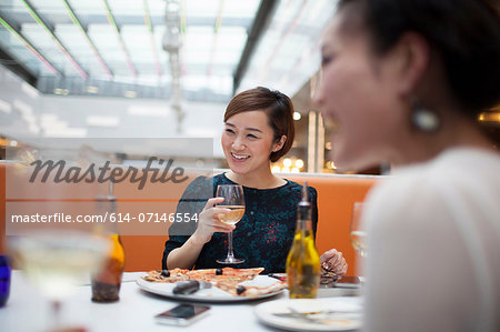 Young women in restaurant eating pizza