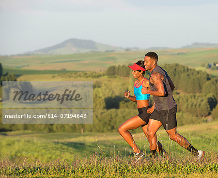 Man and woman running in landscape, Othello, Washington, USA Man and woman running in landscape, Othello, Washington, USA