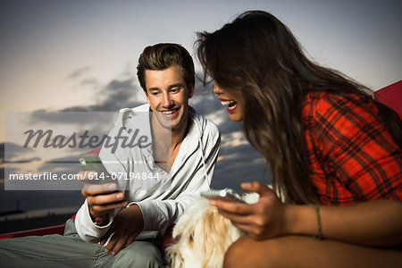 Young couple with cell phone, San Diego, California, USA