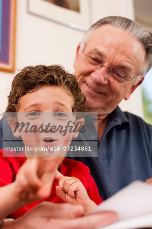 Portrait of young boy and grandfather playing