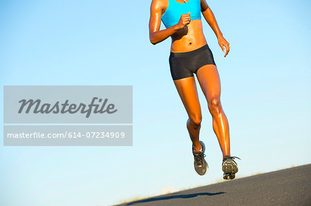 Detail of young woman running on road Detail of young woman running on road