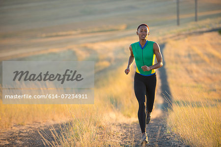 Young woman running on dirt track, Bainbridge Island, Washington State, USA Young woman running on dirt track, Bainbridge Island, Washington State, USA
