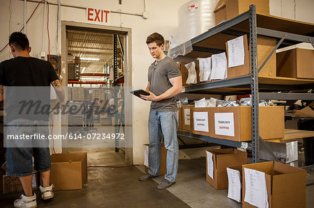 Workers in warehouse looking at paperwork
