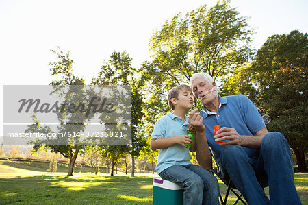 Grandfather and grandson blowing bubbles