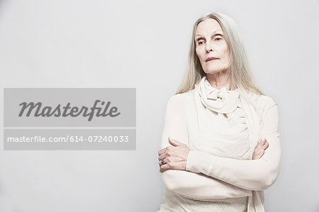 Studio portrait of senior woman with arms crossed