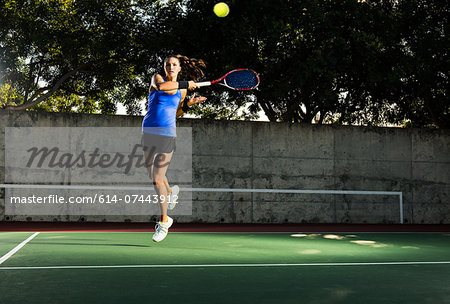 Female tennis player hitting ball