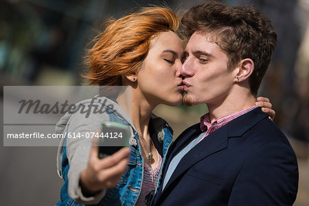 Couple taking selfies in the city