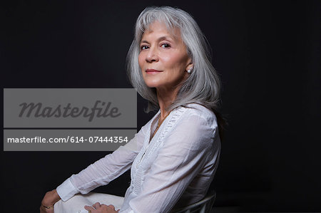 Studio portrait of aloof senior woman