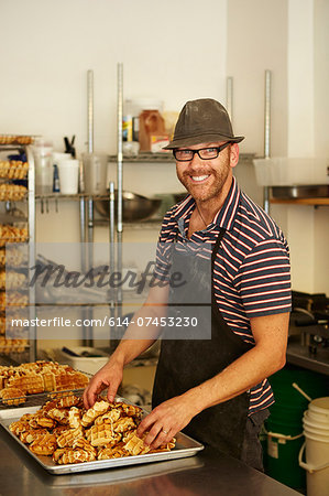 Male baker with tray of waffles in bakery Male baker with tray of waffles in bakery